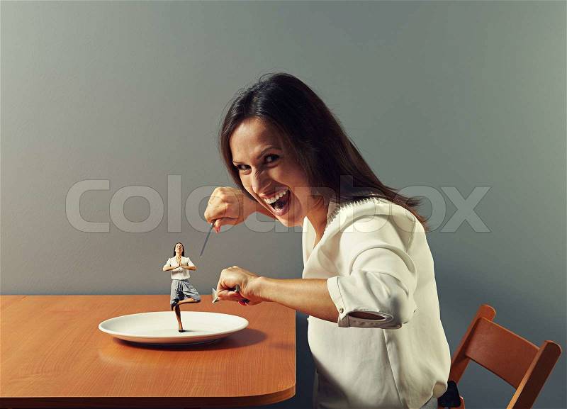Evil woman ready to eat small meditation woman, stock photo