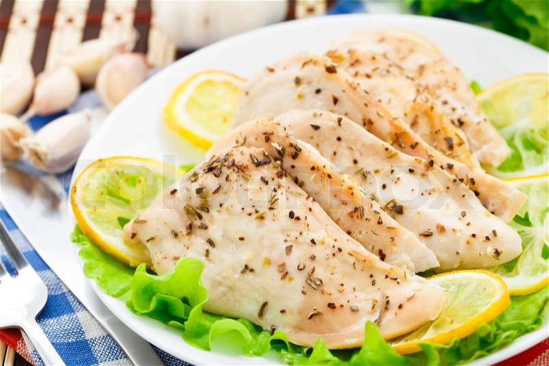 Chicken breast with lemon and garlic on a plate, stock photo