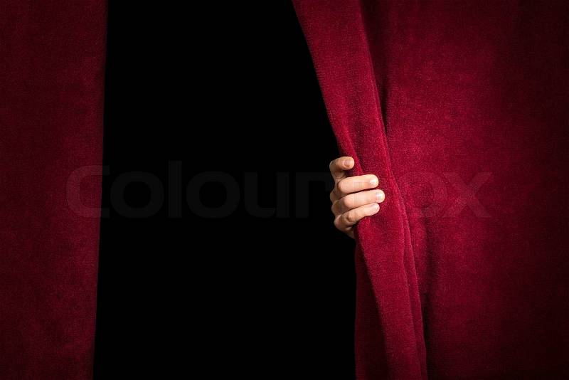 Hand appearing beneath the curtain. Red curtain, stock photo