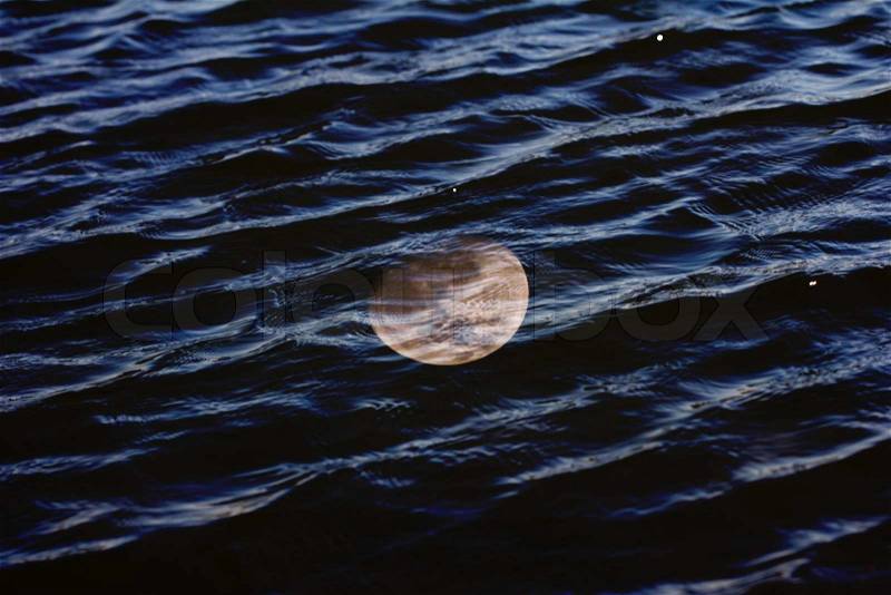 Moon reflected in water with waves, stock photo