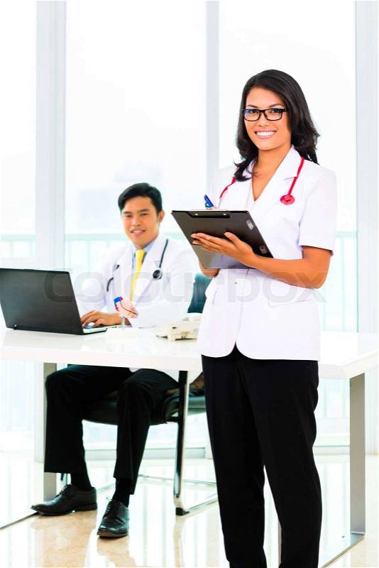 Asian doctor and nurse working in medical office or practice, stock photo