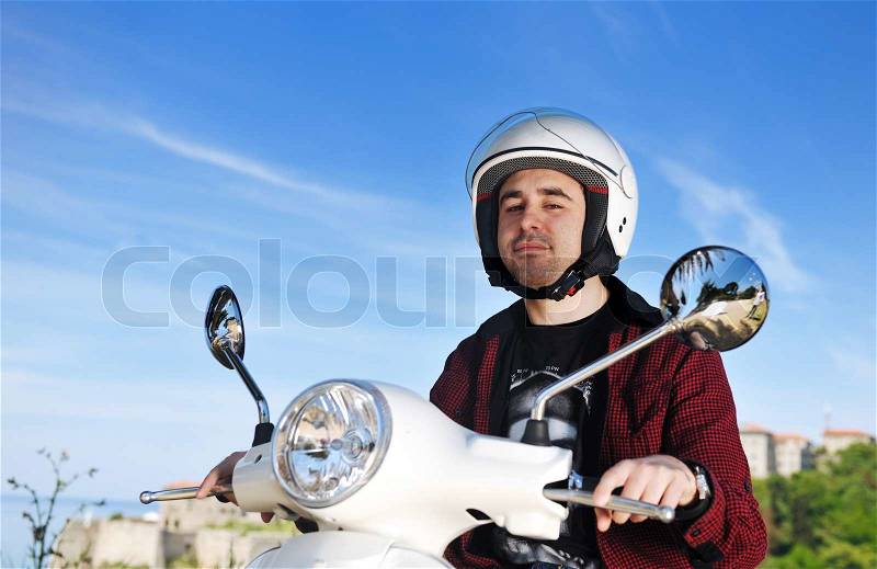 Young man ride white retro vintage motorbike scooter, stock photo