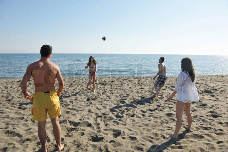 Young people group have fun and play beach volleyball at sunny summer day, stock photo
