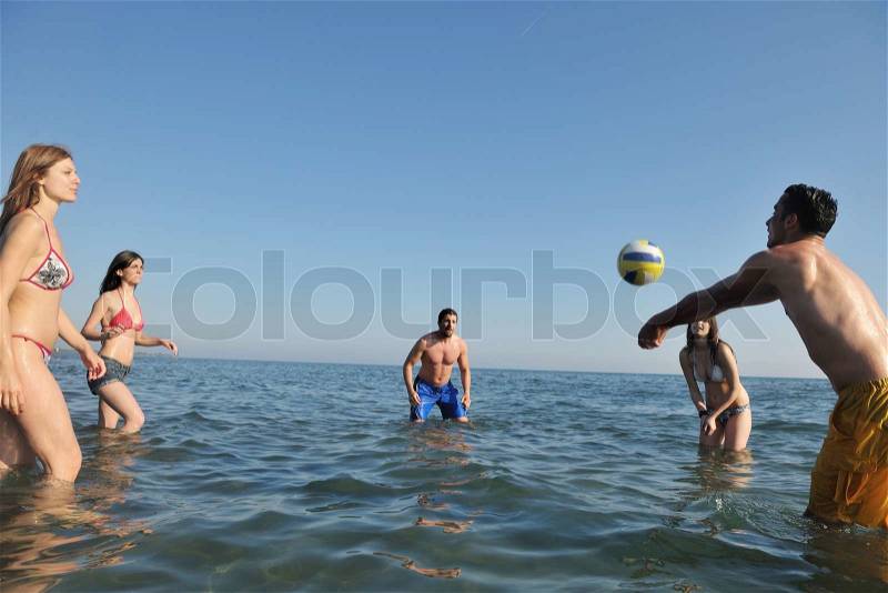 Young people group have fun and play beach volleyball at sunny summer day, stock photo