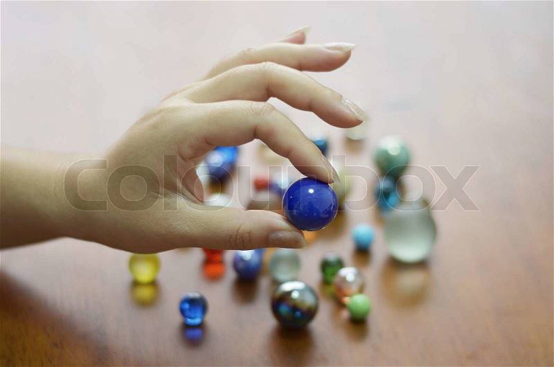 Hand holding glass marble balls, stock photo