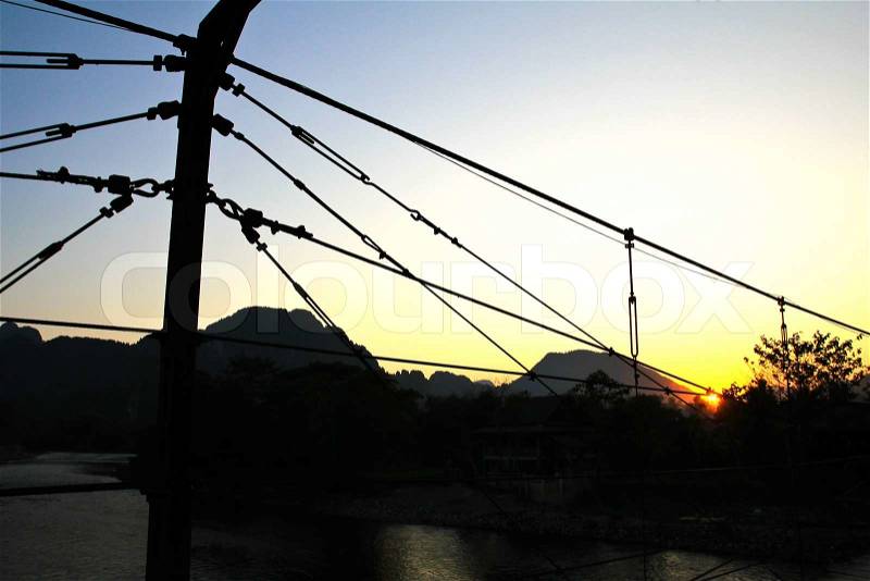 Silhouette of Bridge over Song River at sunset, Vang Vieng, Laos, stock photo