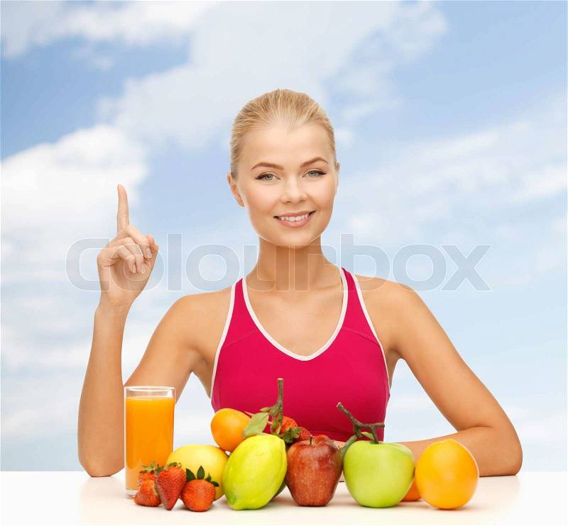 Fitness, diet and food concept - young woman with organic food or fruits holding finger up, stock photo