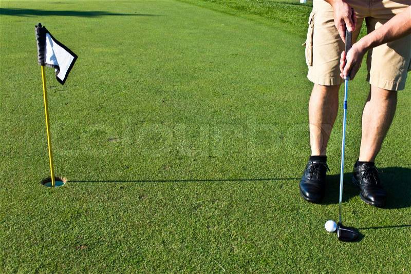 Golfer putting the golf ball, stock photo
