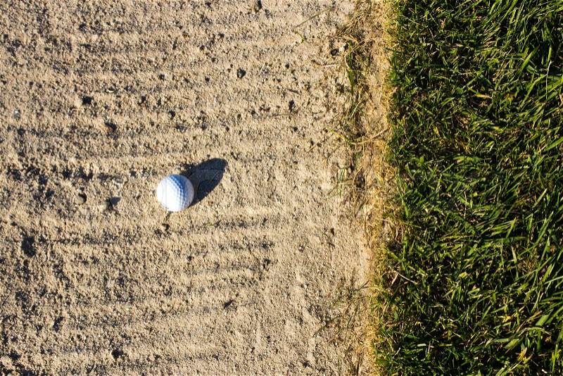 Golf ball in the sand trap, stock photo
