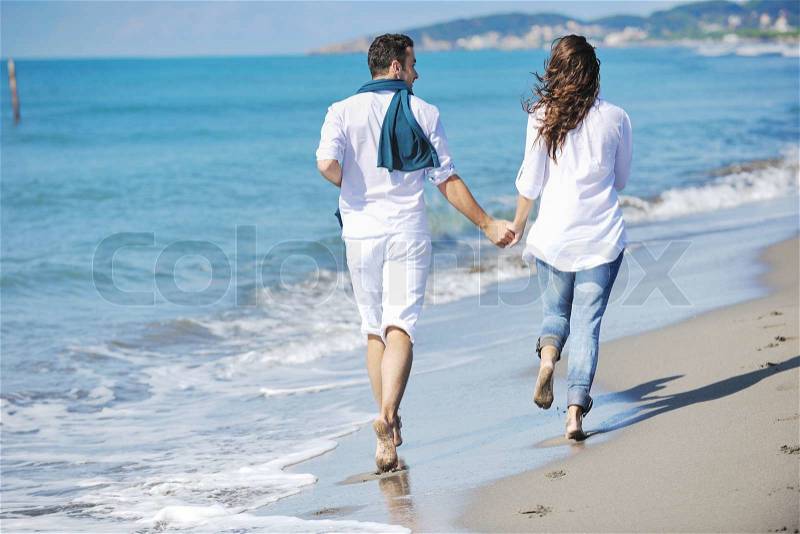 Happy young couple in white clothing have romantic recreation and fun at beautiful beach on vacations, stock photo