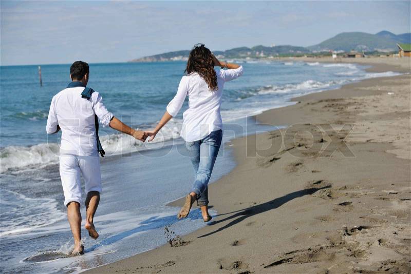 Happy young couple in white clothing have romantic recreation and fun at beautiful beach on vacations, stock photo