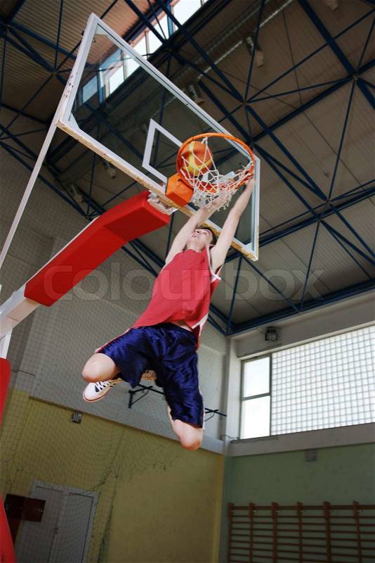 Young healthy man play basketball game indoor in gym, stock photo