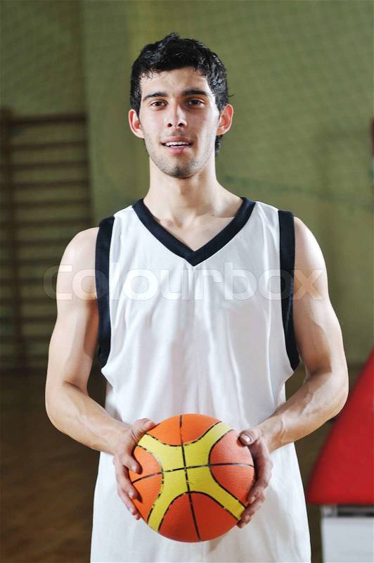 One basket ball game player standing in sport gym with ball, stock photo