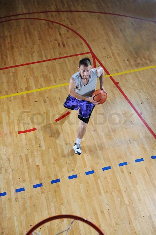One healthy young man play basketball game in school gym indoor, stock photo