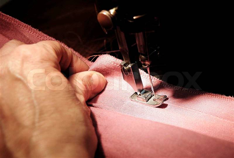 To sew a material on the sewing machine, stock photo