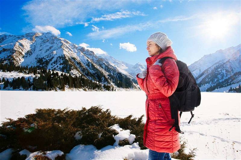 Young woman take a walk on winter mountain slope (Big Almaty Lake, Kazakhstan), stock photo