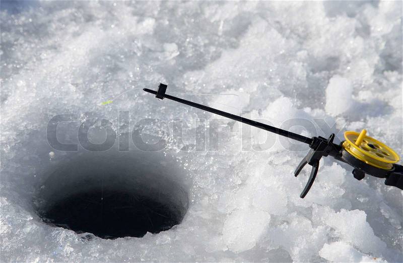 Fishing line in hole drilled in ice, stock photo