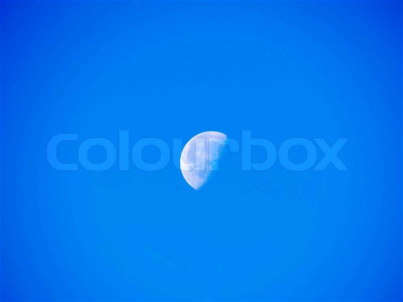 Bright half moon in the sky of noon, stock photo