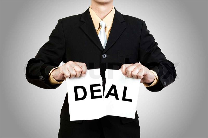 Businessman tear paper with word Deal on gray background, stock photo