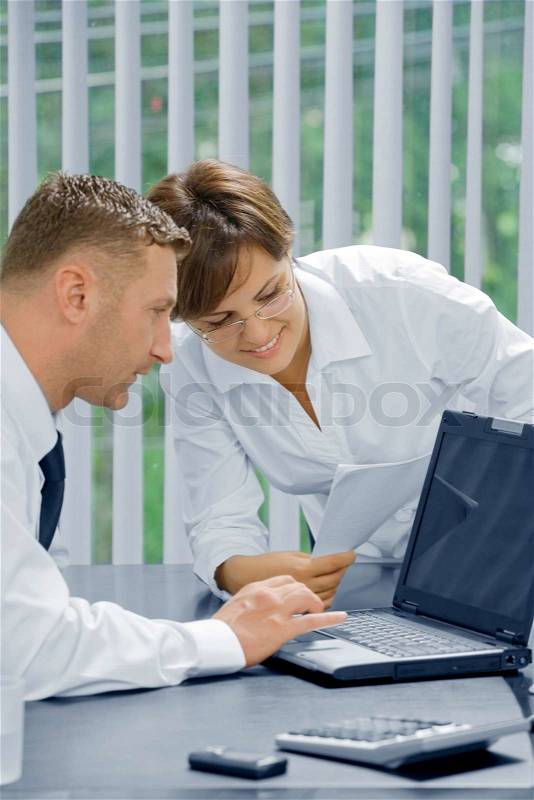 Portrait of young business people discussing project in office environment, stock photo
