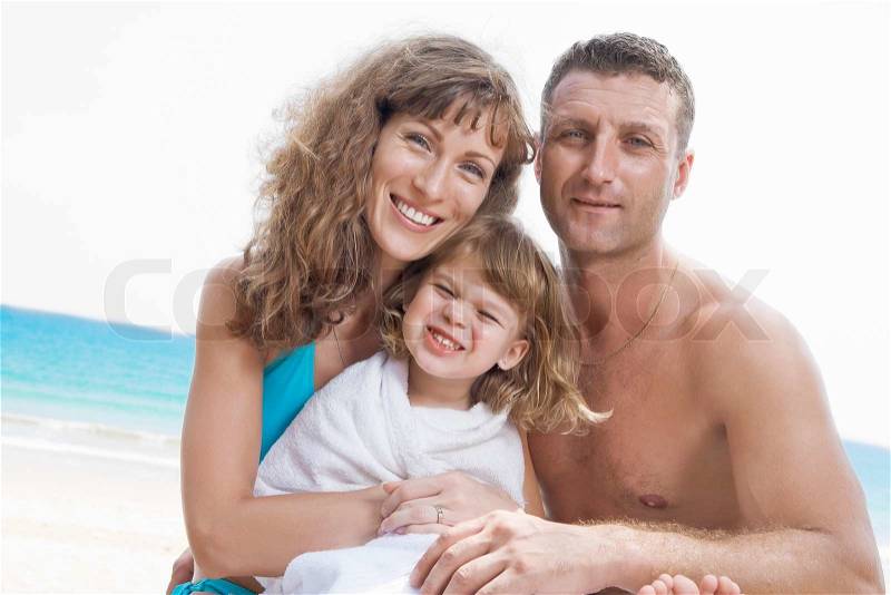 Portrait of young family having fun on the beach, stock photo