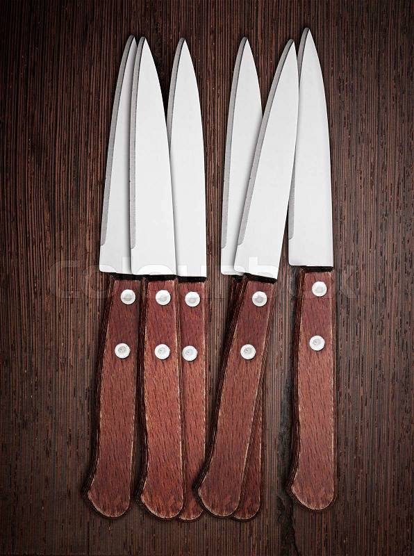 Six Knifes on rustic kitchen table, stock photo