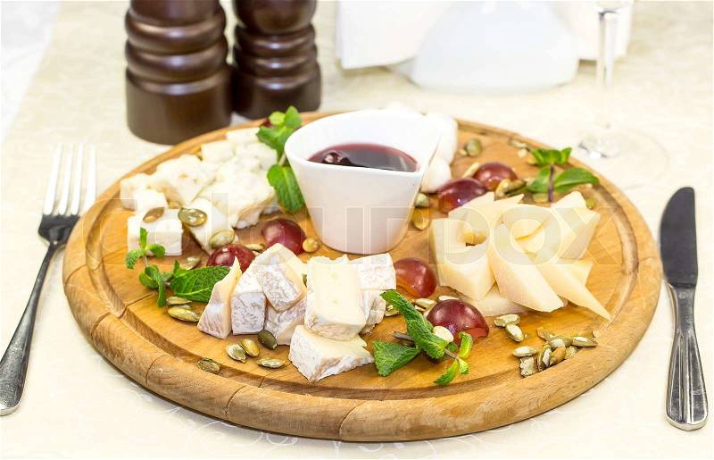 Cheese plate with several varieties of cheese in the restaurant, stock photo