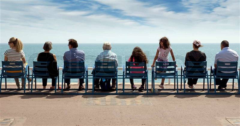 NICE, FRANCE - MAY 2: People sit on chairs along Promenade des Anglais and enjoy the view of the Mediterranean Sea on May 2, 2013 in Nice, France. Nice is a popular Mediterranean tourist destination, attracting 4 million visitors each year, stock photo