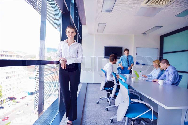 Business woman with her staff, people group in background at modern bright office indoors, stock photo