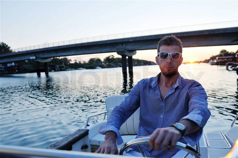 Happy young man have fun at boat at sunset on summer season, stock photo