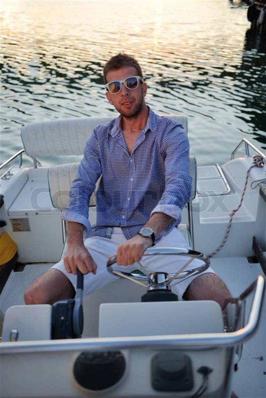 Happy young man have fun at boat at sunset on summer season, stock photo