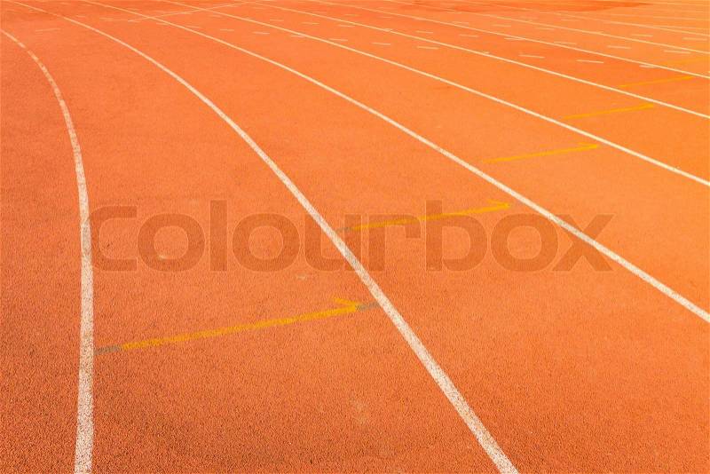Red color and texture of athletics track lanes with white line, stock photo