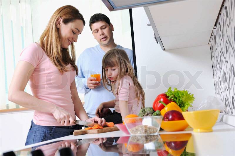 Happy young family have lunch time with fresh fruits and vegetable food in bright kitchen , stock photo