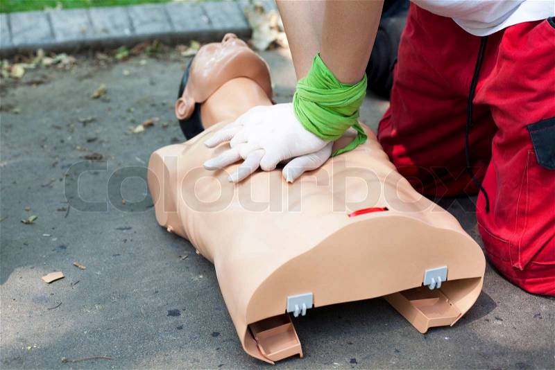 Paramedic demonstrates CPR on dummy, stock photo