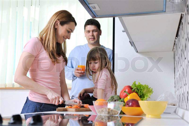 Happy young family have lunch time with fresh fruits and vegetable food in bright kitchen, stock photo