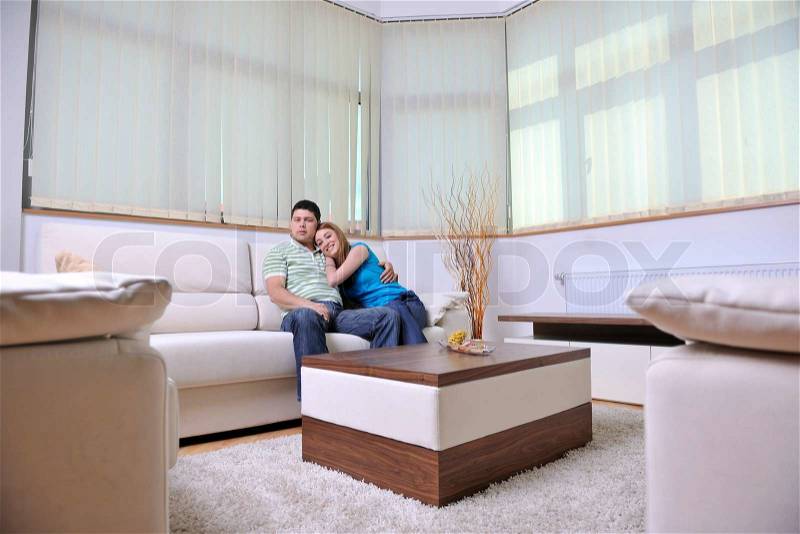 Happy young couple relax at home in modern and bright living room, stock photo