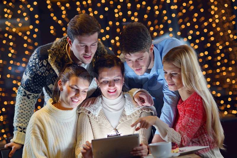 Group of happy people looking at a tablet computer, stock photo