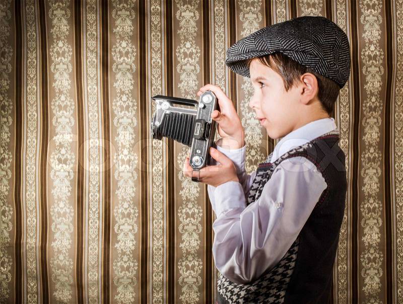 Child taking pictures with vintage camera, stock photo