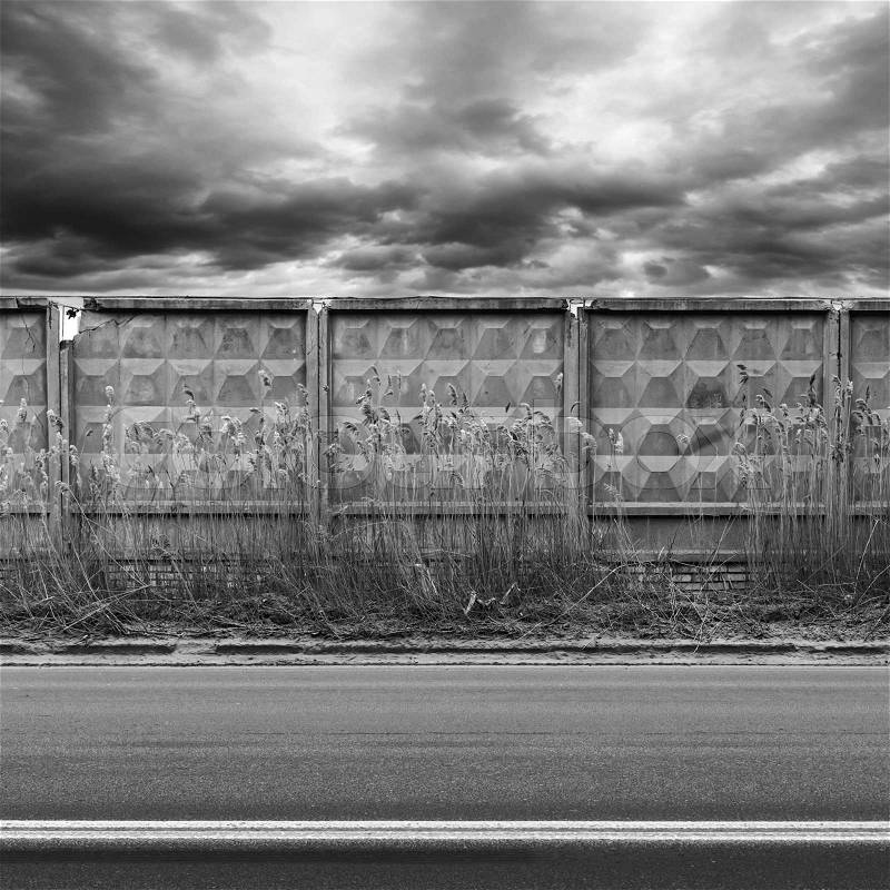 Dark urban road with concrete fence. Black and white photo, stock photo