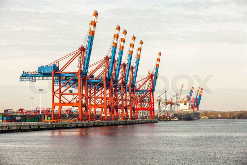 Deserted port terminal in a harbour for loading and offloading cargo ships and freight with rows of large industrial cranes to lift goods off the decks and from the holds, stock photo