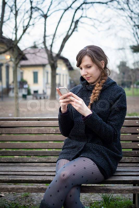 Young hipster beautiful woman using device tablet at the park, stock photo