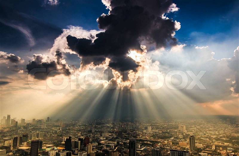 Rays of light shining through dark clouds city Bangkok, Thailand, stock photo