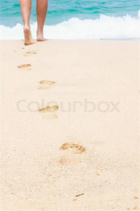 Human footprints on the white sandy beach, stock photo