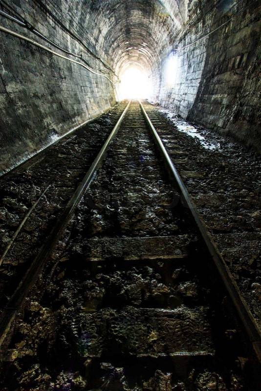Light at the end of railroad tunnel. Natural lighting, stock photo