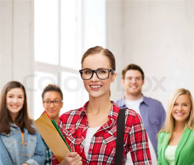 Education and people concept - female student in eyeglasses with bag and folders, stock photo