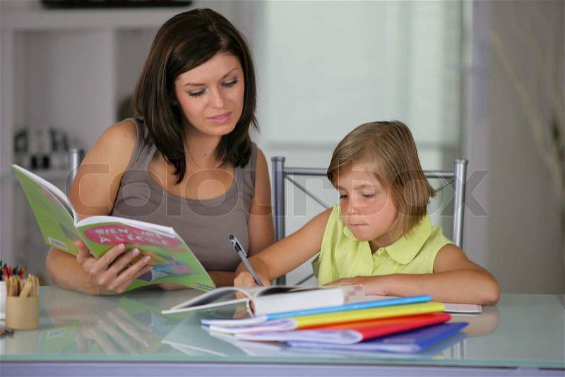 Mother helping daughter with schoolwork, stock photo
