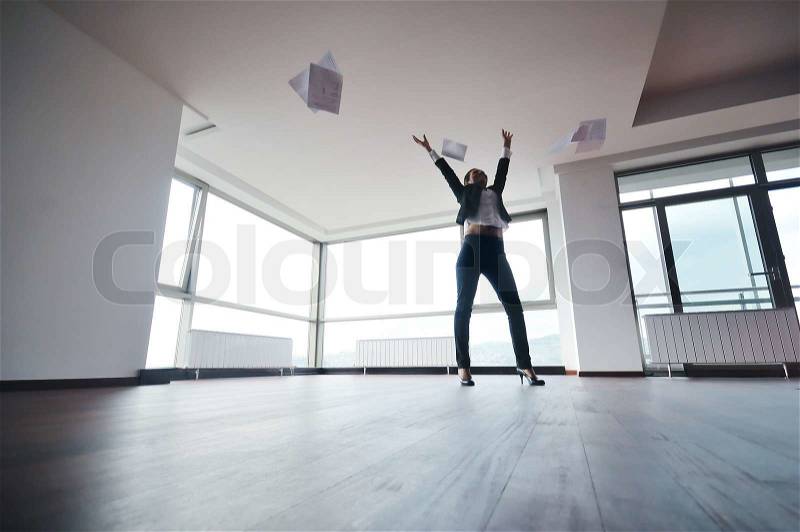 Young business woman throw papers and documents from joy in air representing concept of freedom joy and stress control, stock photo