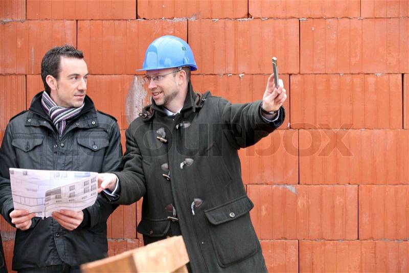 Architect and client on site, stock photo