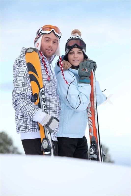 Couple about to ski down mountain, stock photo