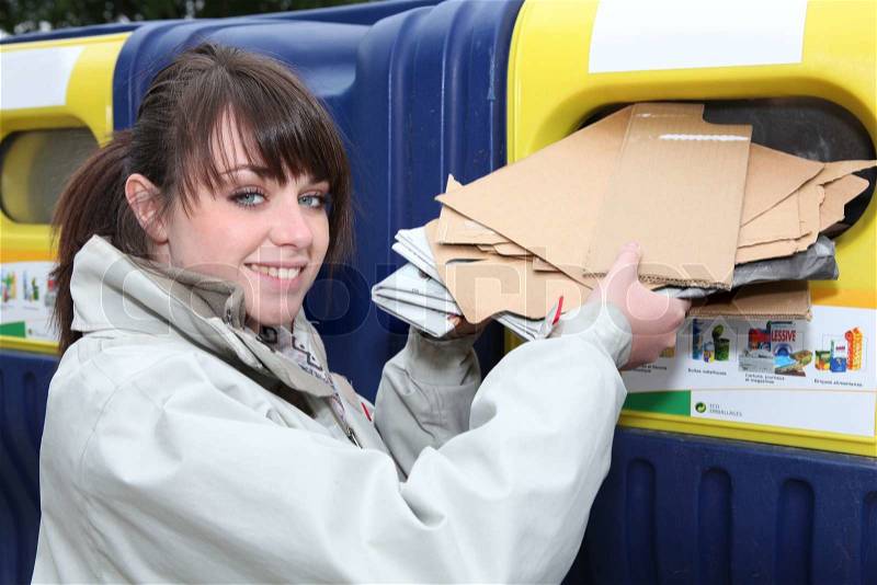 Woman using paper recycling bin, stock photo